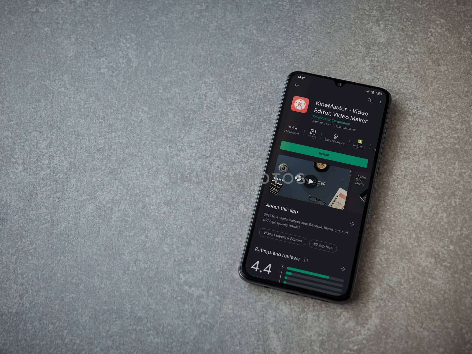 Lod, Israel - July 8, 2020: KineMaster - Video Editor and Movie Maker app play store page on the display of a black mobile smartphone on ceramic stone background. Top view flat lay with copy space.