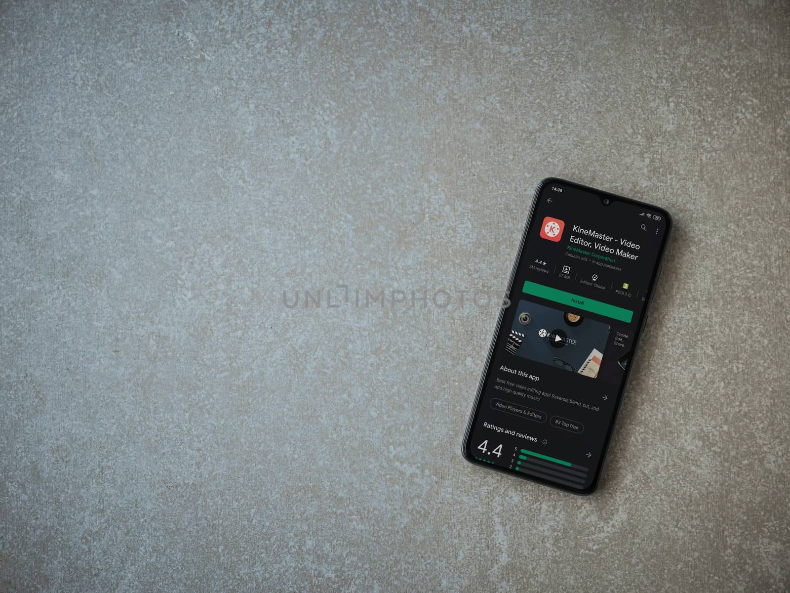 Lod, Israel - July 8, 2020: KineMaster - Video Editor and Movie Maker app play store page on the display of a black mobile smartphone on ceramic stone background. Top view flat lay with copy space.