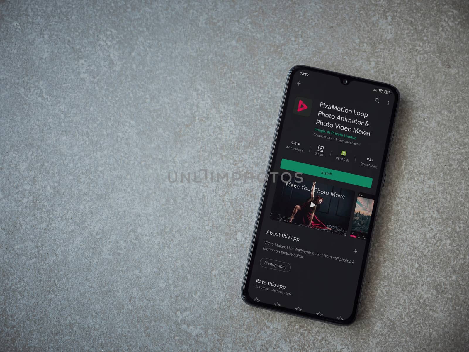 Lod, Israel - July 8, 2020: PixaMotion app play store page on the display of a black mobile smartphone on ceramic stone background. Top view flat lay with copy space.