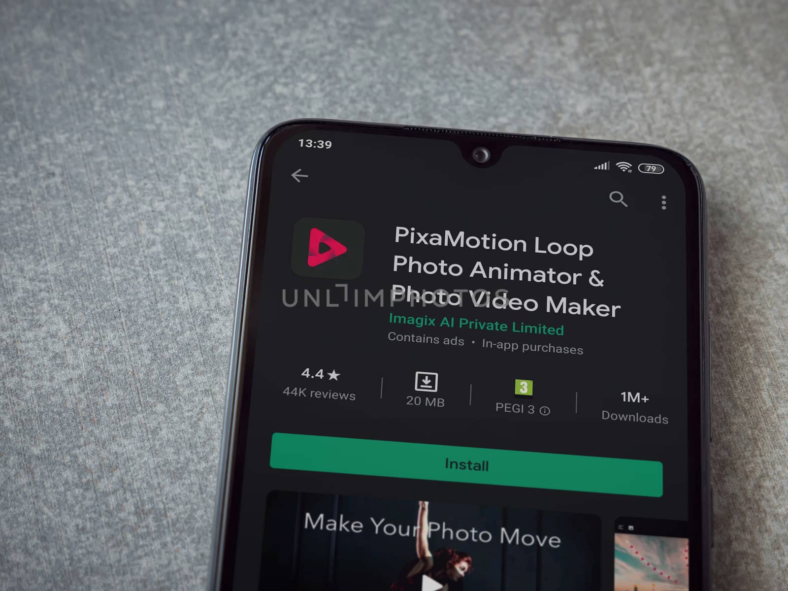 Lod, Israel - July 8, 2020: PixaMotion app play store page on the display of a black mobile smartphone on ceramic stone background. Top view flat lay with copy space.