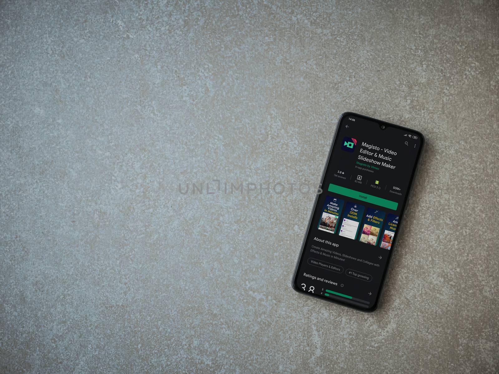 Lod, Israel - July 8, 2020: Magisto - Video Editor and Movie Maker app play store page on the display of a black mobile smartphone on ceramic stone background. Top view flat lay with copy space.