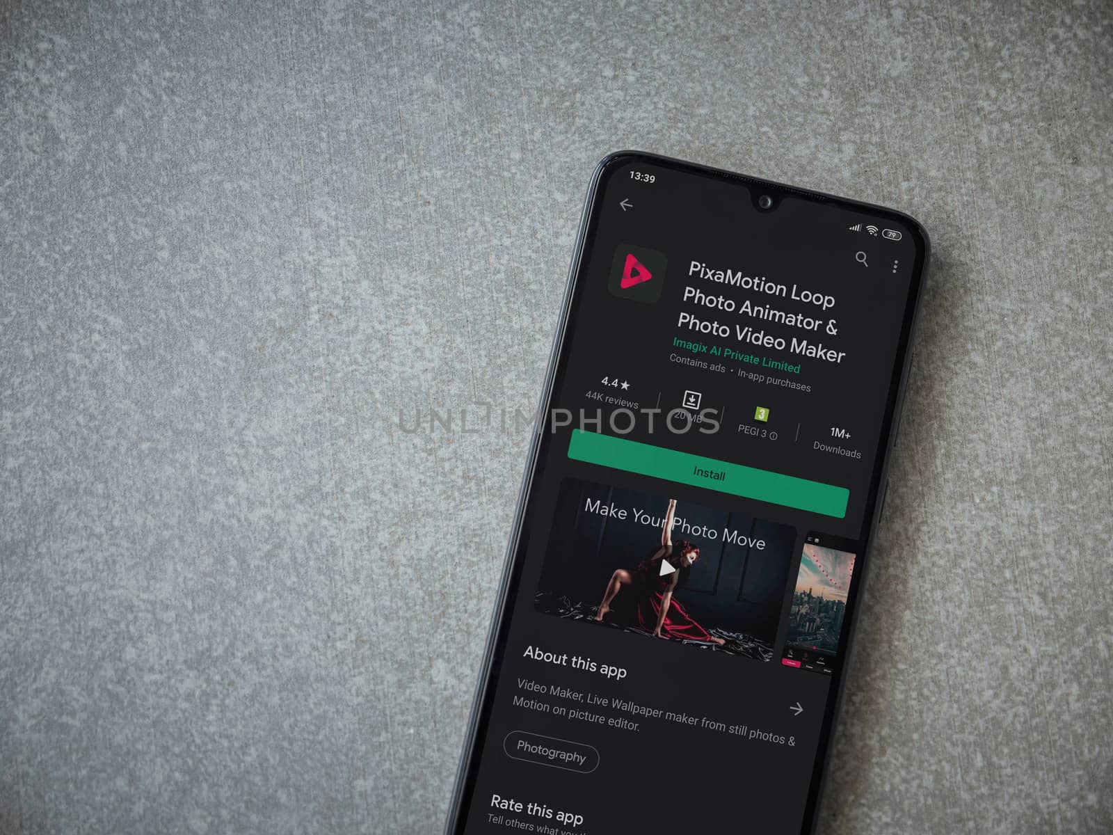 Lod, Israel - July 8, 2020: PixaMotion app play store page on the display of a black mobile smartphone on ceramic stone background. Top view flat lay with copy space.