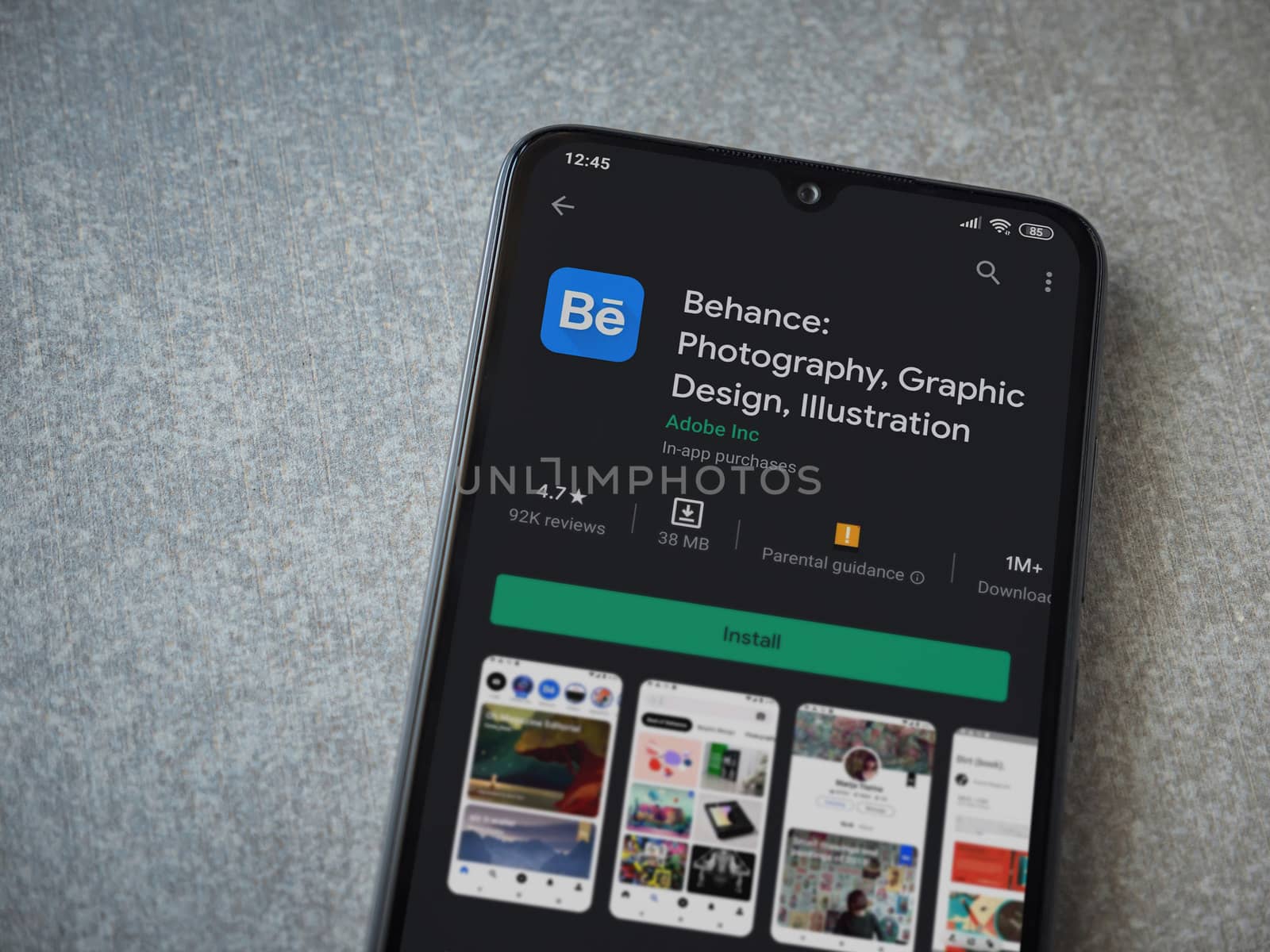 Lod, Israel - July 8, 2020: Adobe Behance app play store page on the display of a black mobile smartphone on ceramic stone background. Top view flat lay with copy space. 