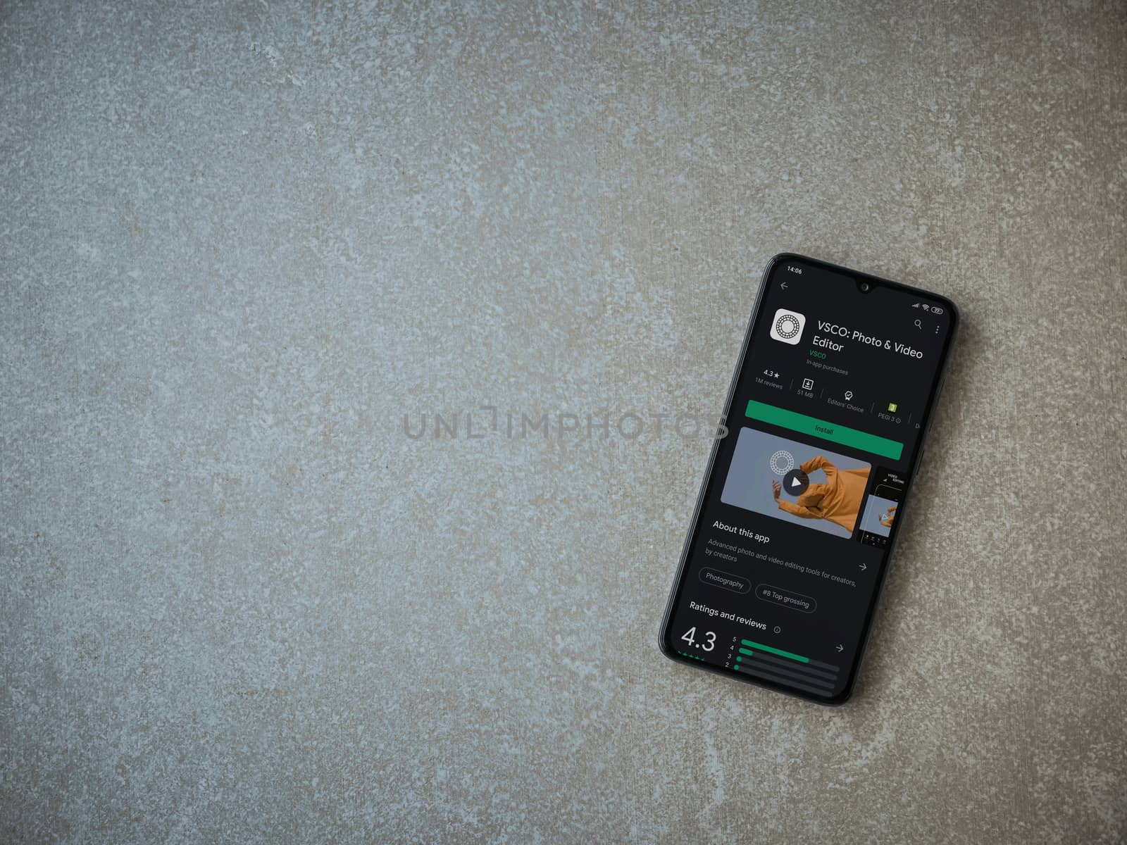 Lod, Israel - July 8, 2020: VSCO - Photo and Video Editor app play store page on the display of a black mobile smartphone on ceramic stone background. Top view flat lay with copy space. 