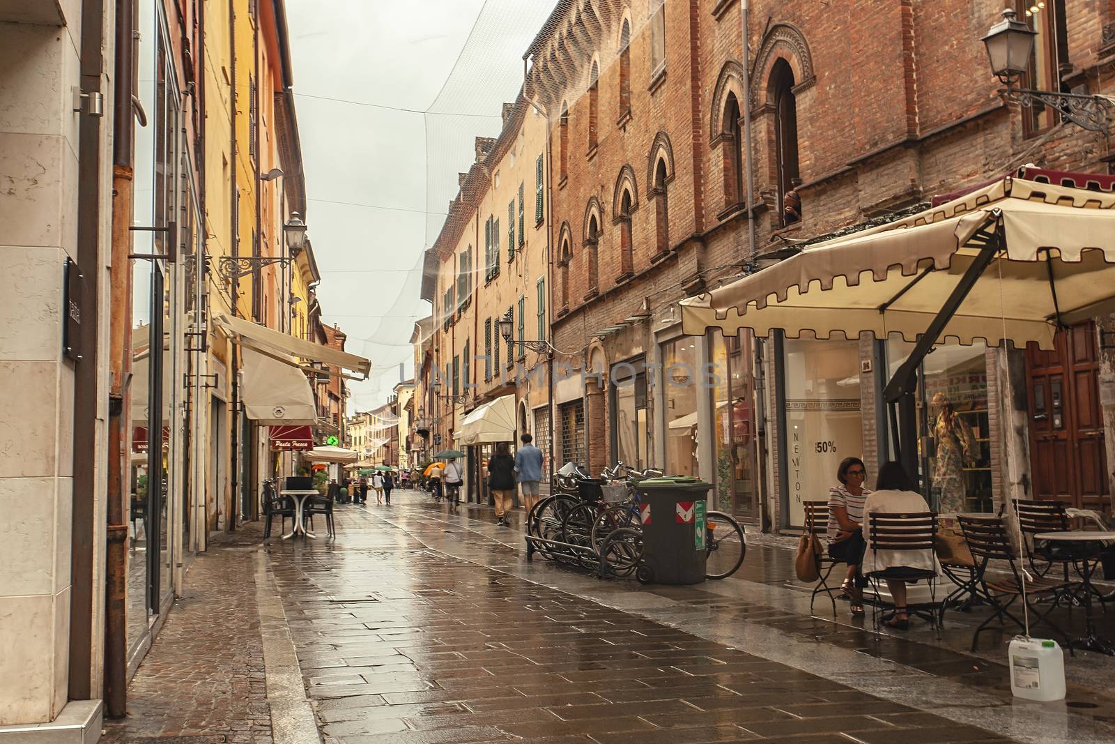 FERRARA, ITALY 29 JULY 2020 : Alley with people walking in Ferrara in Italy