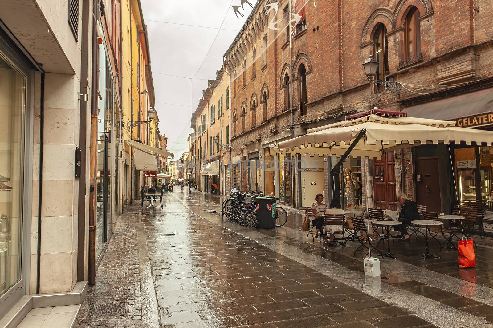 FERRARA, ITALY 29 JULY 2020 : Alley with people walking in Ferrara in Italy