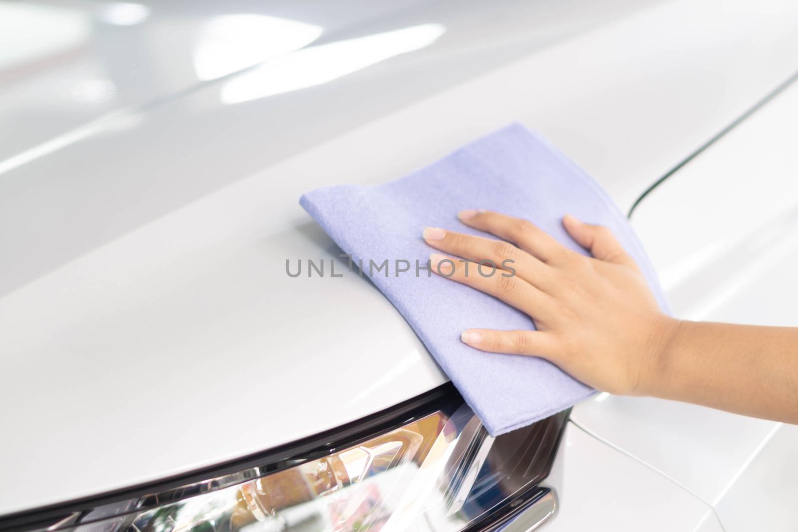 Man cleaning car with microfiber cloth, car detailing (or valeting) concept. Selective focus.