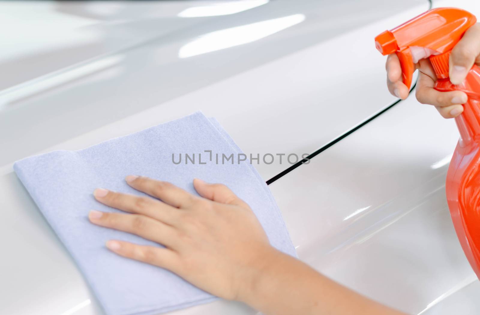 Man cleaning car with microfiber cloth, car detailing (or valeting) concept. Selective focus.