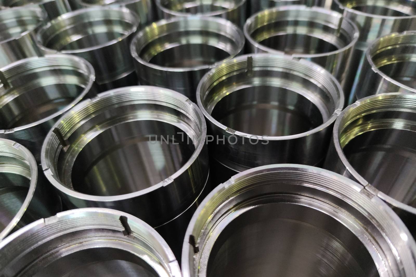 A close-up shot of shiny steel aerospace cnc turned tubes in a batch with selective focus and background blur.