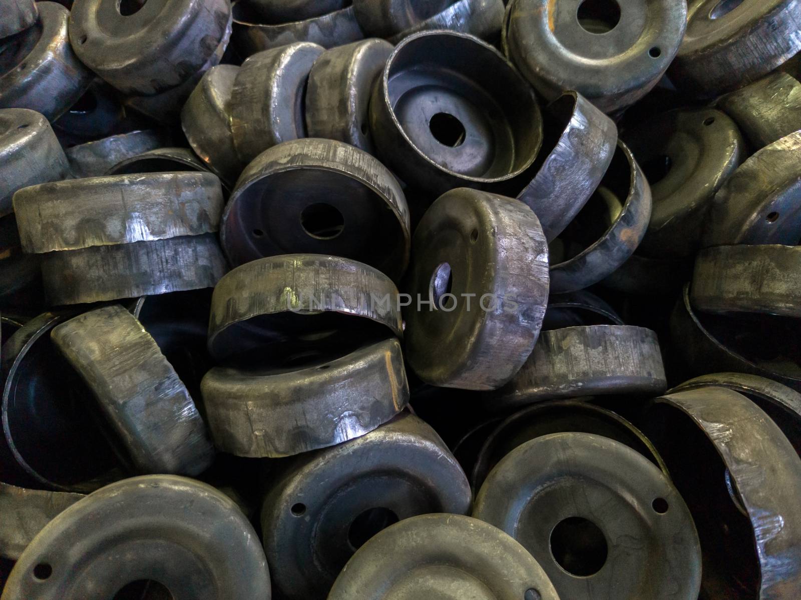 a pile of dirty black stamped metal round shells after a hood operation