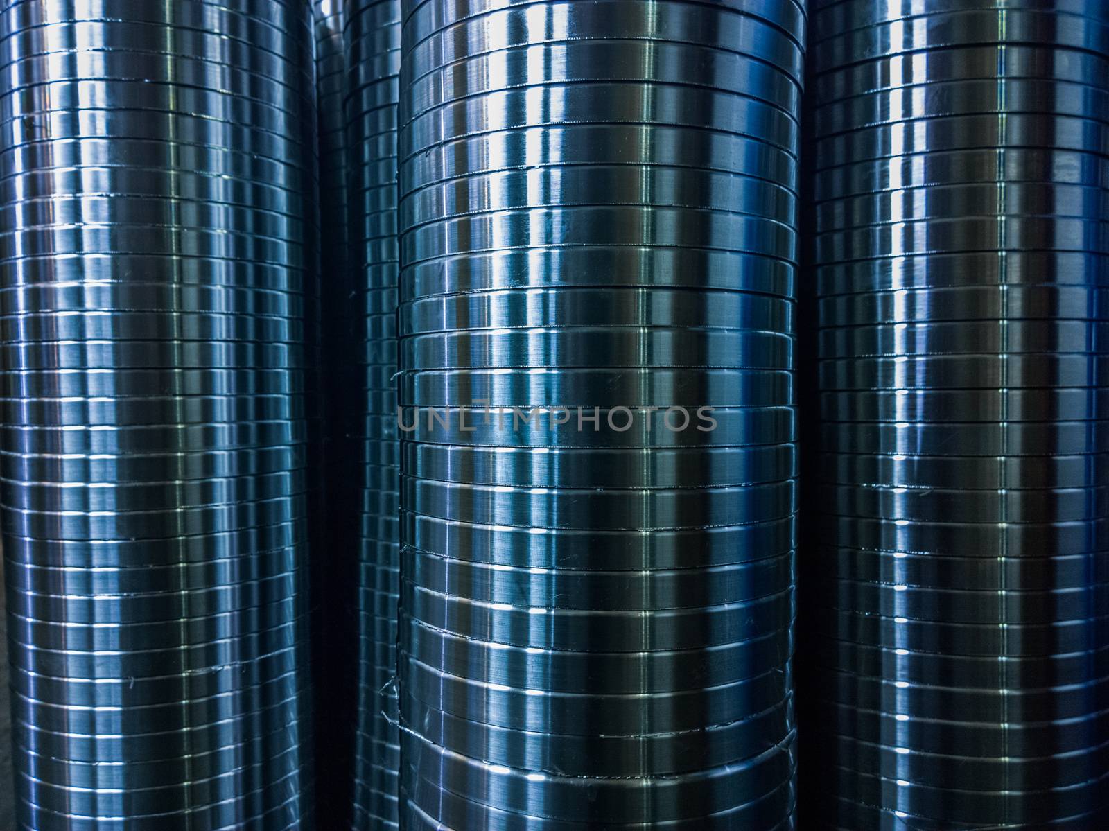 industrial manufacturing background of columns of shiny metal rings after cnc turning operation. Selective focus technique.
