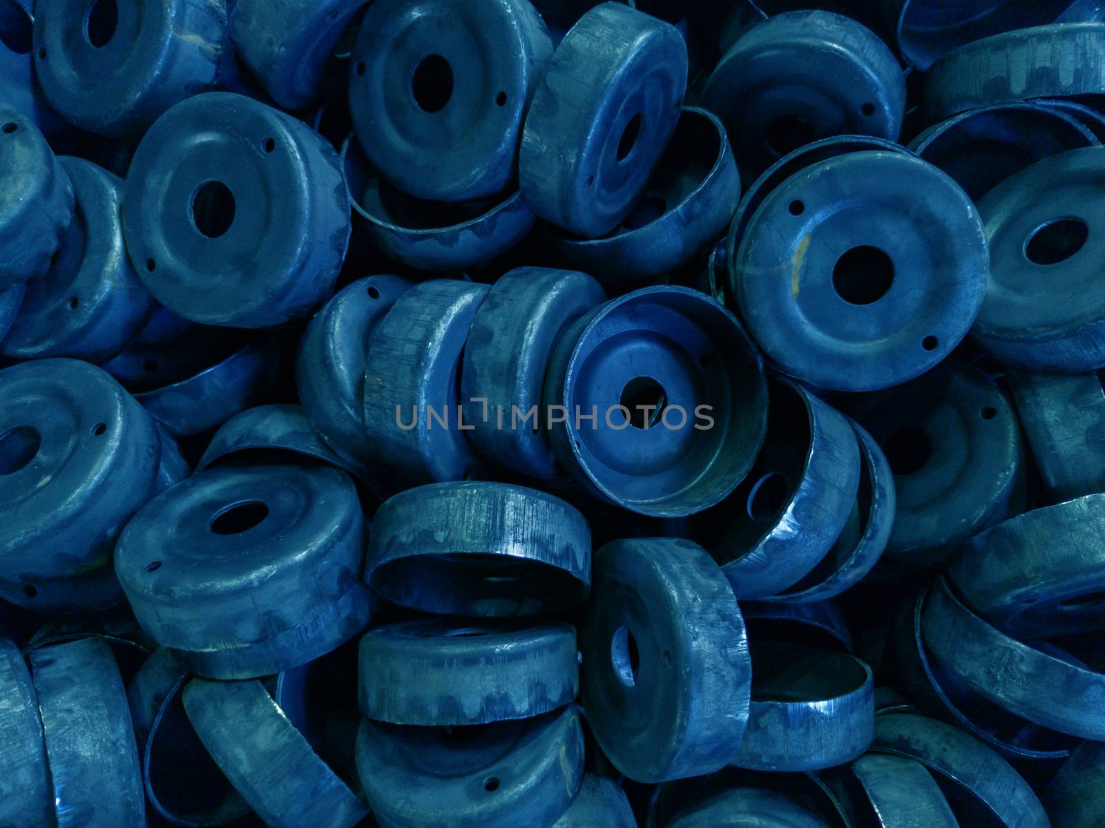 a pile of dirty black stamped metal round shells after a hood operation - - classic blue color toned