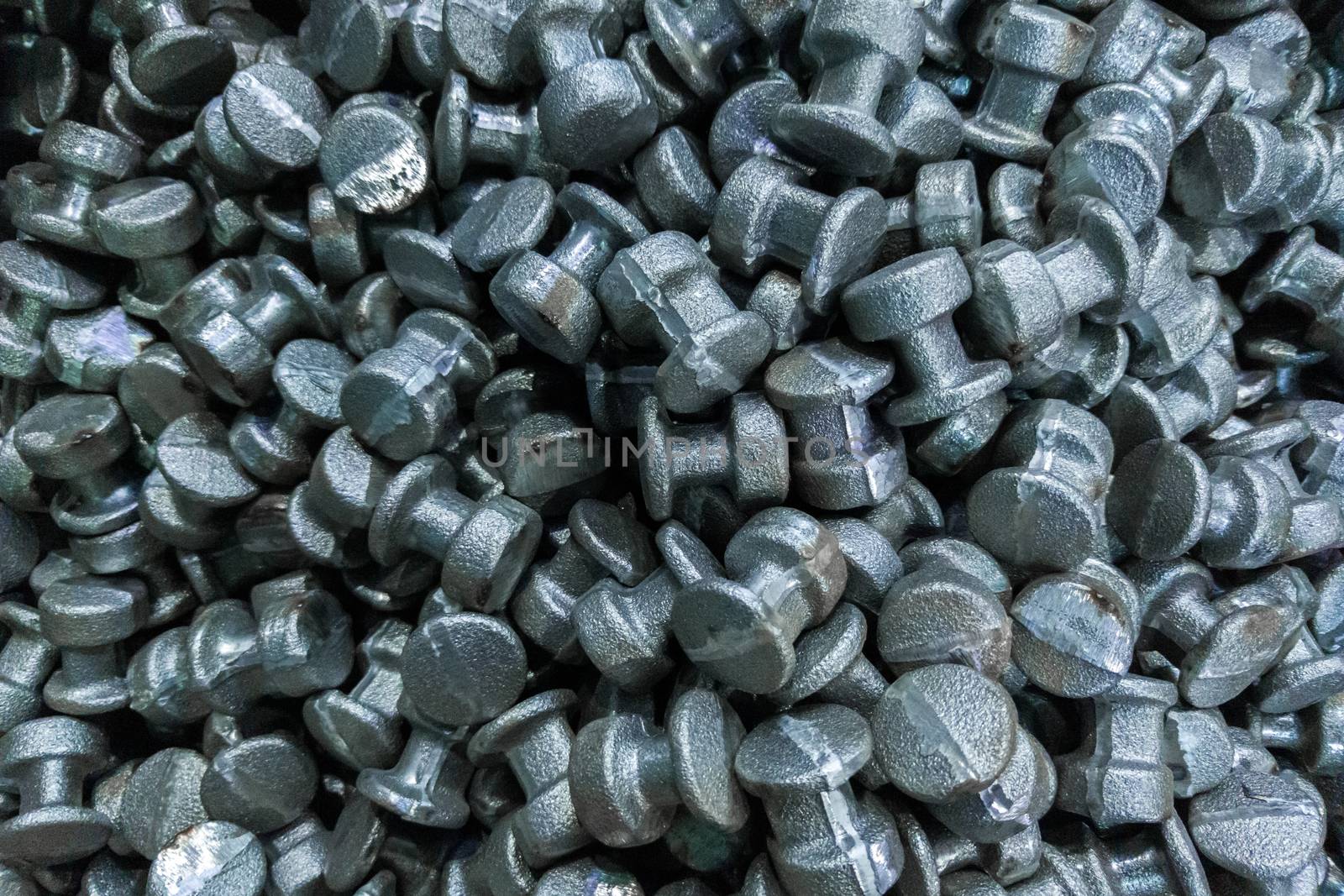 An abstract industrial full frame background of forged and sanded steel billets. Close-up with selective focus and optical blur.