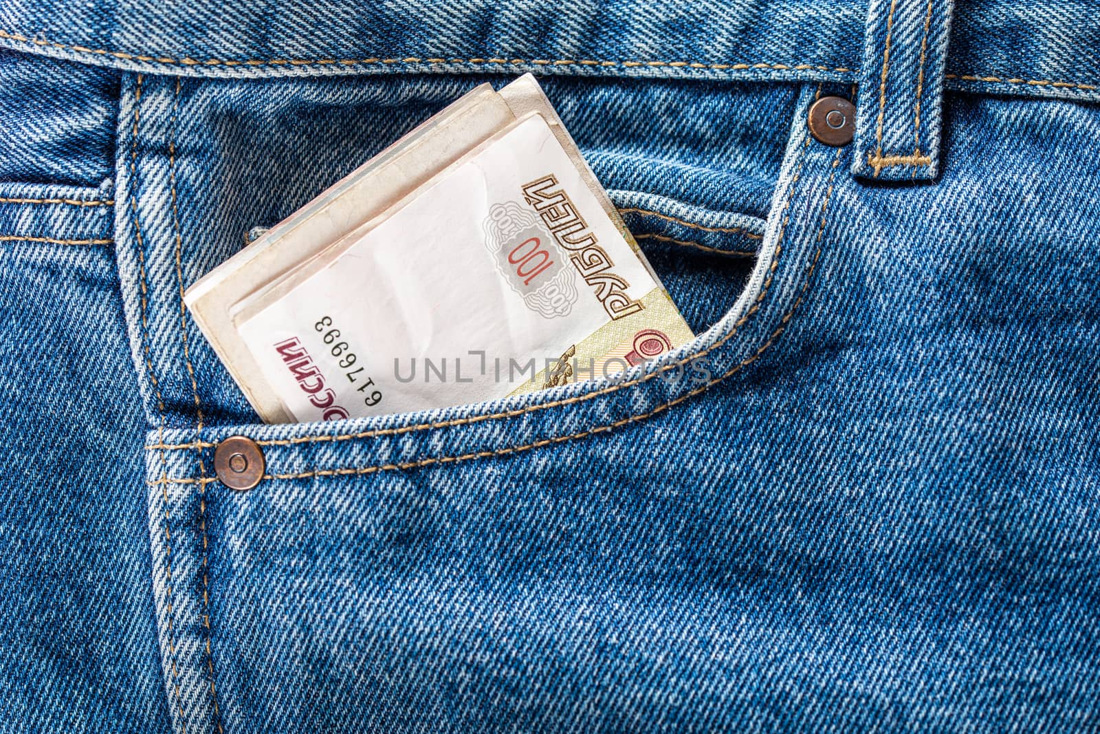russian ruble banknotes in the front left pocket of blue jeans. Concept of saving money or pocket expenses.