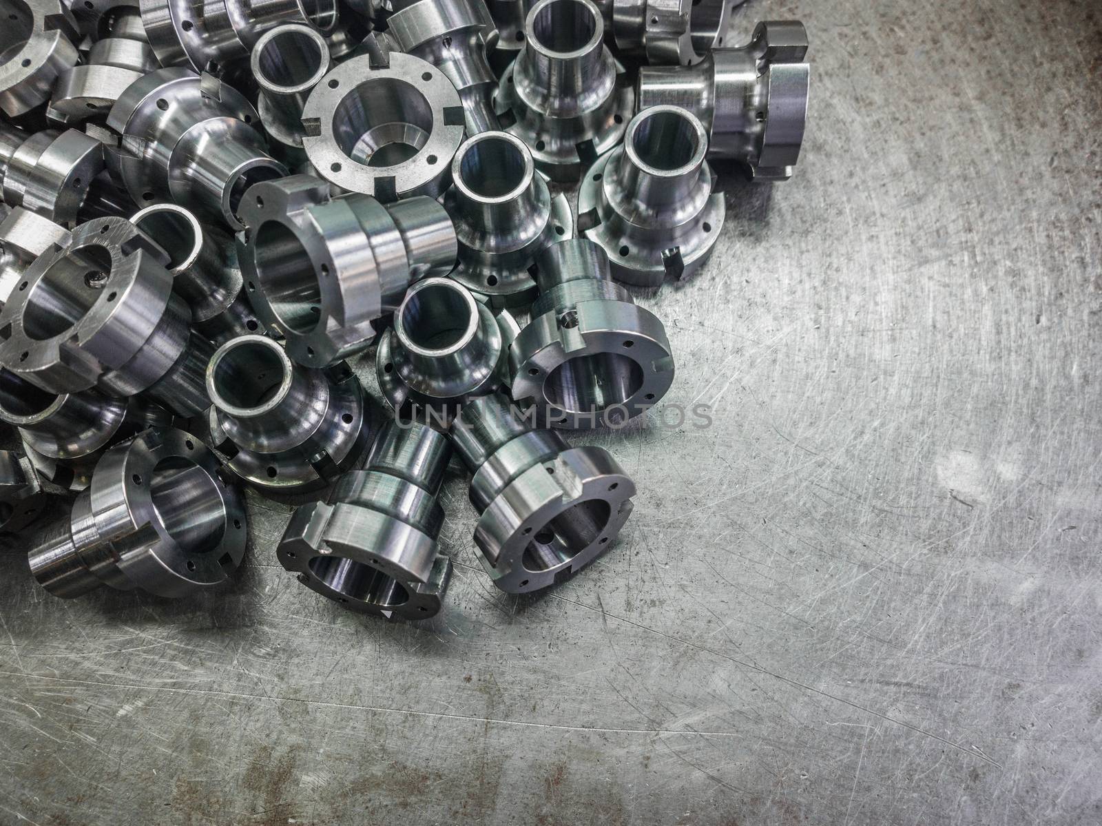 Shiny steel parts after cnc turning, drilling and machining on steel surface selective focus composition background.