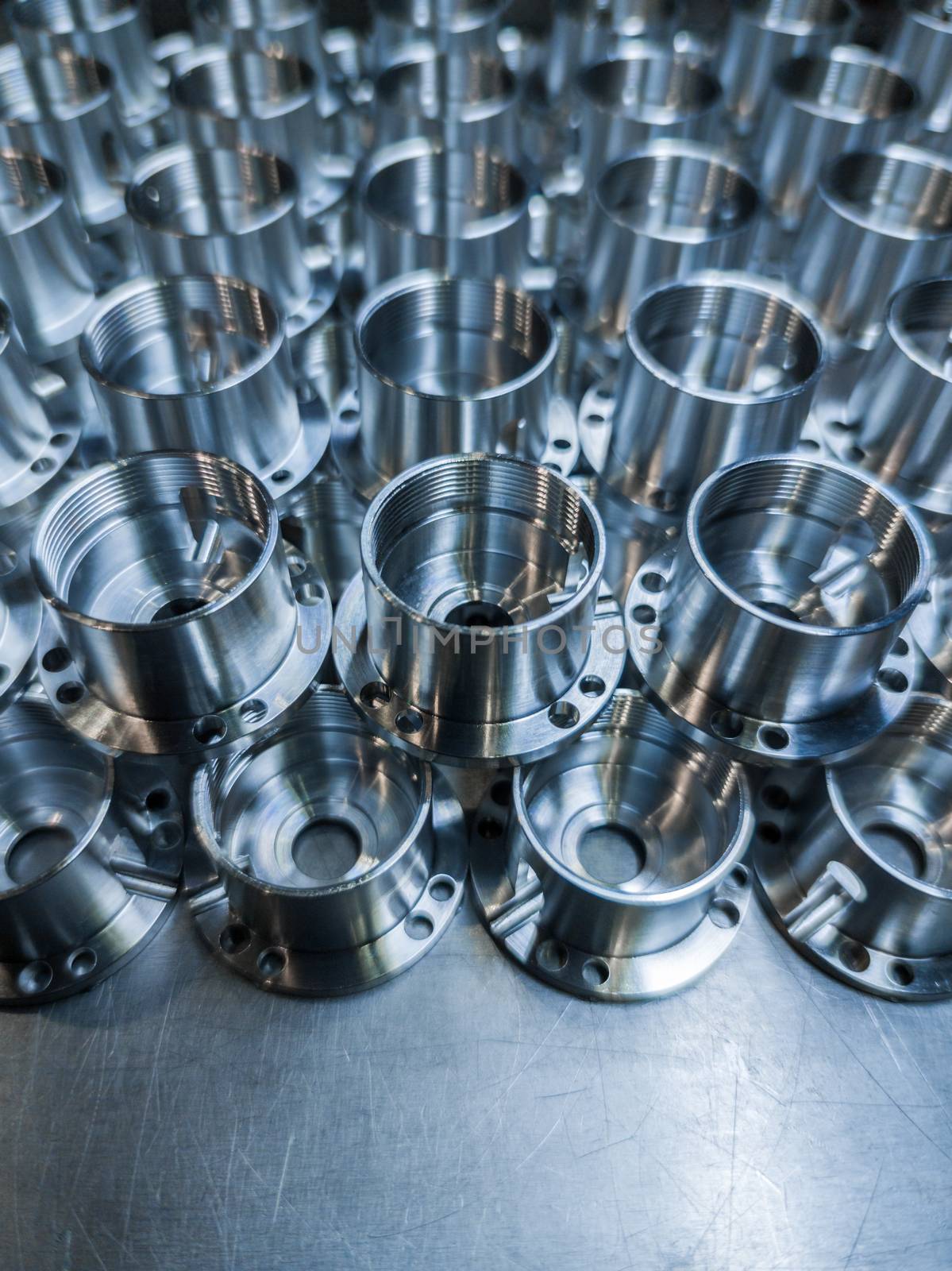 a batch of shiny metal cnc aerospace parts production - close-up with selective focus for industrial full frame manufacturing background.