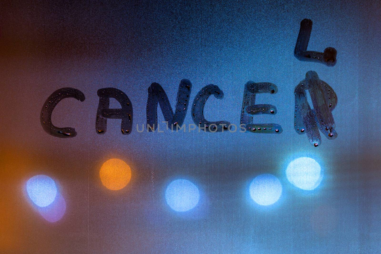 The word work out written on night sweaty window glass with blurred blue light in the background.