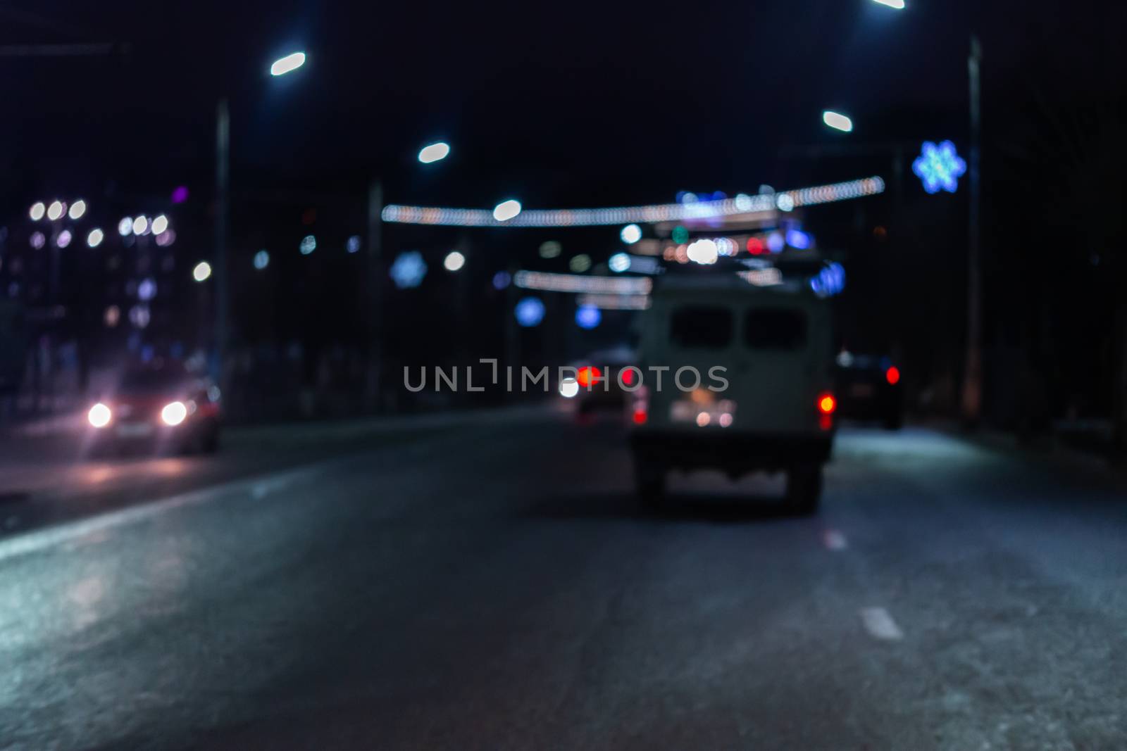 Defocused picture of night street car traffic - view from road. Colorful night life dark background.