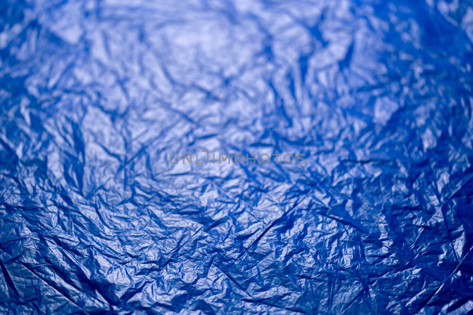 crumpled blue polyethilene film abstract background with selective focus.