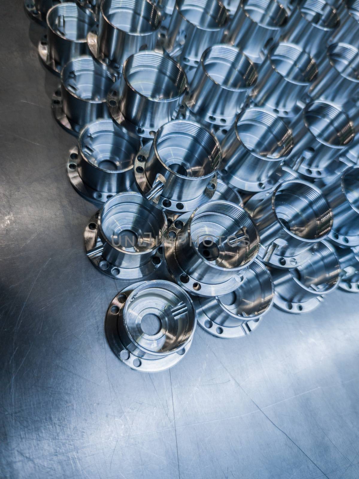 a batch of shiny metal cnc made aerospace parts production - close-up with selective focus for industrial background by z1b