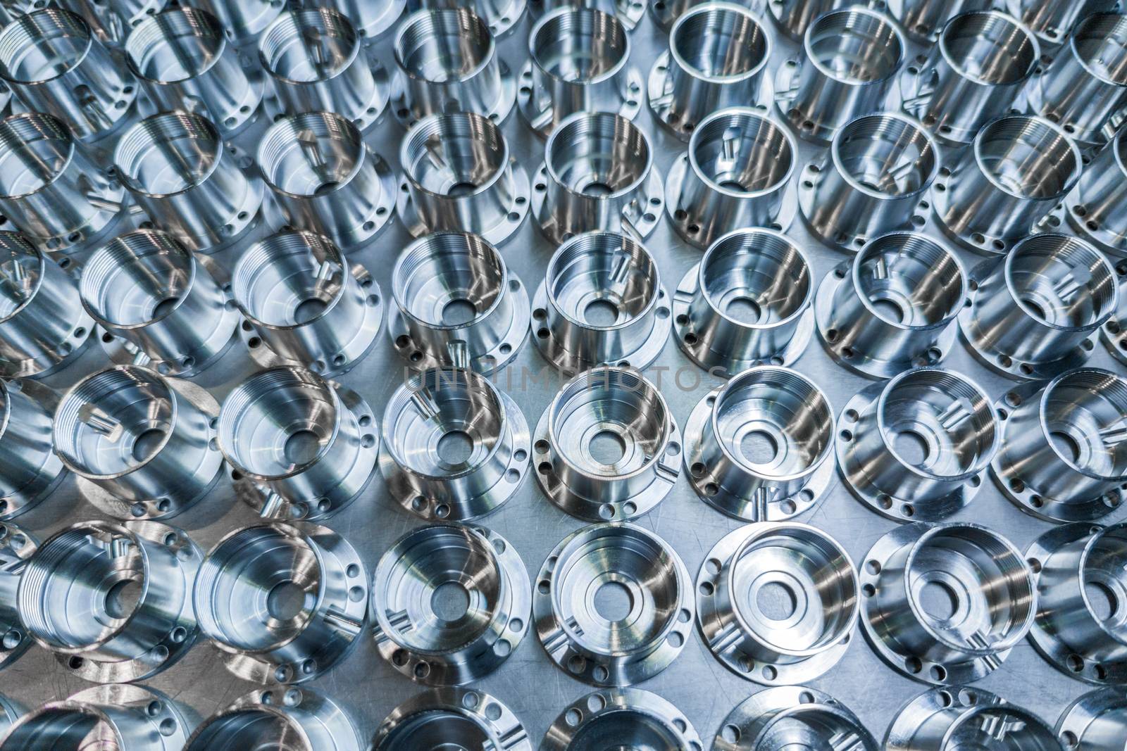 a batch of shiny metal cnc aerospace parts production - close-up with selective focus for industrial full frame background.
