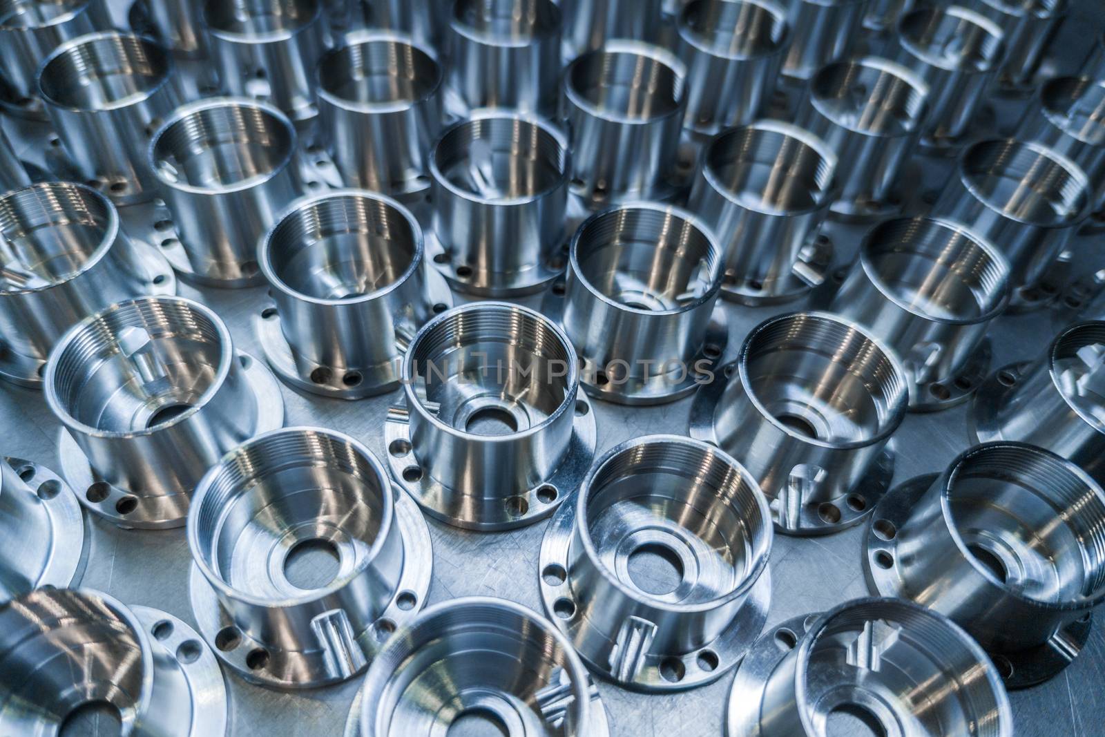 a batch of shiny metal cnc aerospace parts production - close-up with selective focus for industrial background.