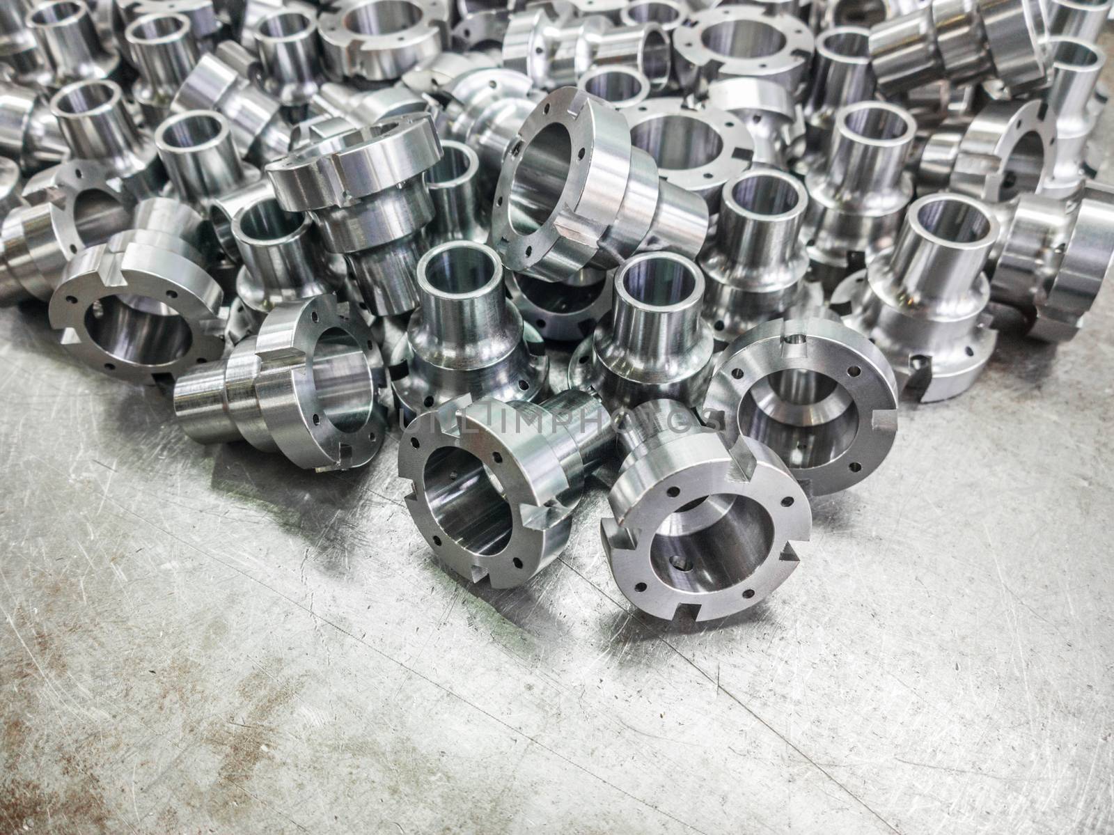 Shiny steel parts after cnc turning, drilling and machining on steel surface selective focus composition background.