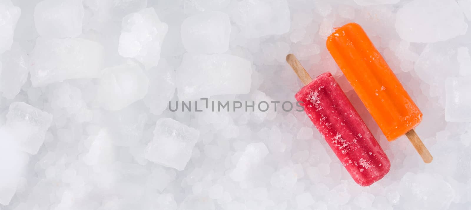 Orange and strawberry popsicles on ice background by chandlervid85