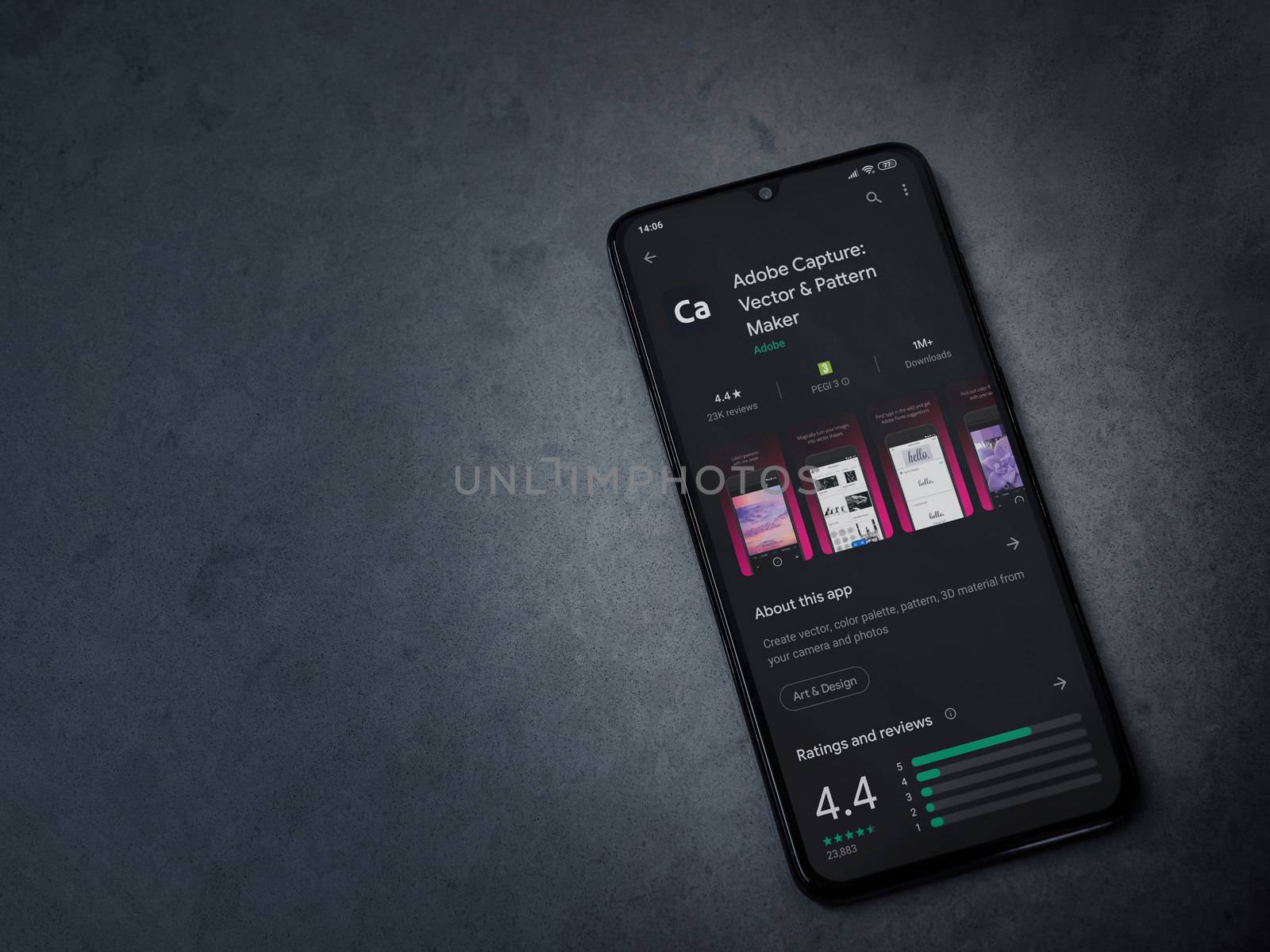 Lod, Israel - July 8, 2020: Adobe Capture - Vector and Pattern Maker app play store page on the display of a black mobile smartphone on a dark marble stone background. Top view flat lay with copy space.