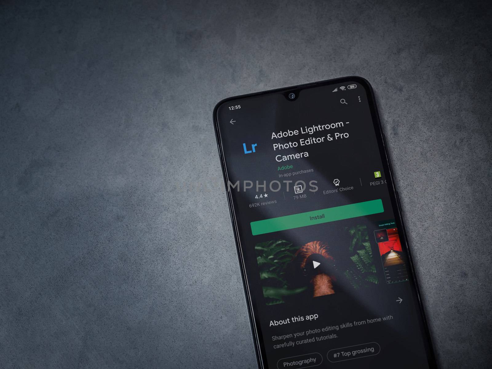 Lod, Israel - July 8, 2020: Adobe Lightroom - Photo Editor and Pro Camera app play store page on the display of a black mobile smartphone on a dark marble stone background. Top view flat lay with copy space.