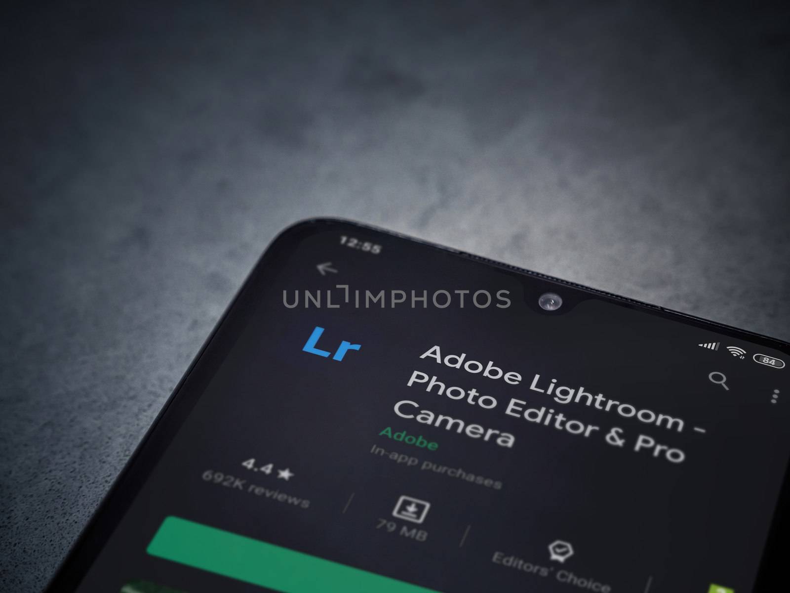 Lod, Israel - July 8, 2020: Adobe Lightroom - Photo Editor and Pro Camera app play store page on the display of a black mobile smartphone on a dark marble stone background. Top view flat lay with copy space.