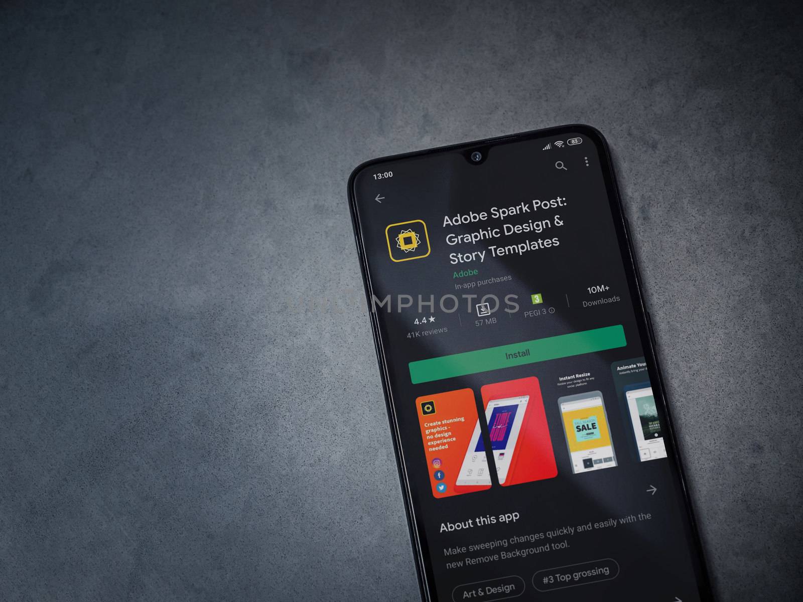 Lod, Israel - July 8, 2020: Adobe Spark Post - Graphic Design and Story Templates app play store page on the display of a black mobile smartphone on a dark marble stone background.Top view flat lay with copy space