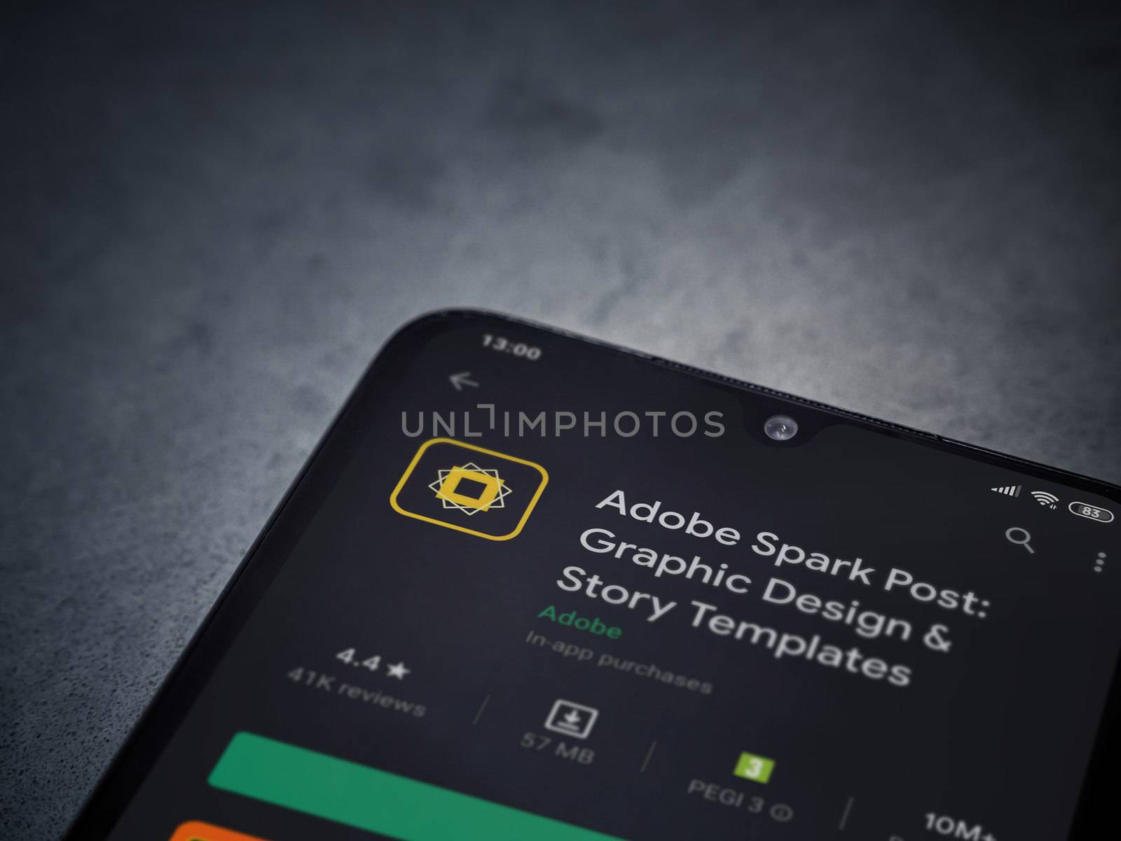 Lod, Israel - July 8, 2020: Adobe Spark Post - Graphic Design and Story Templates app play store page on the display of a black mobile smartphone on a dark marble stone background.Top view flat lay with copy space