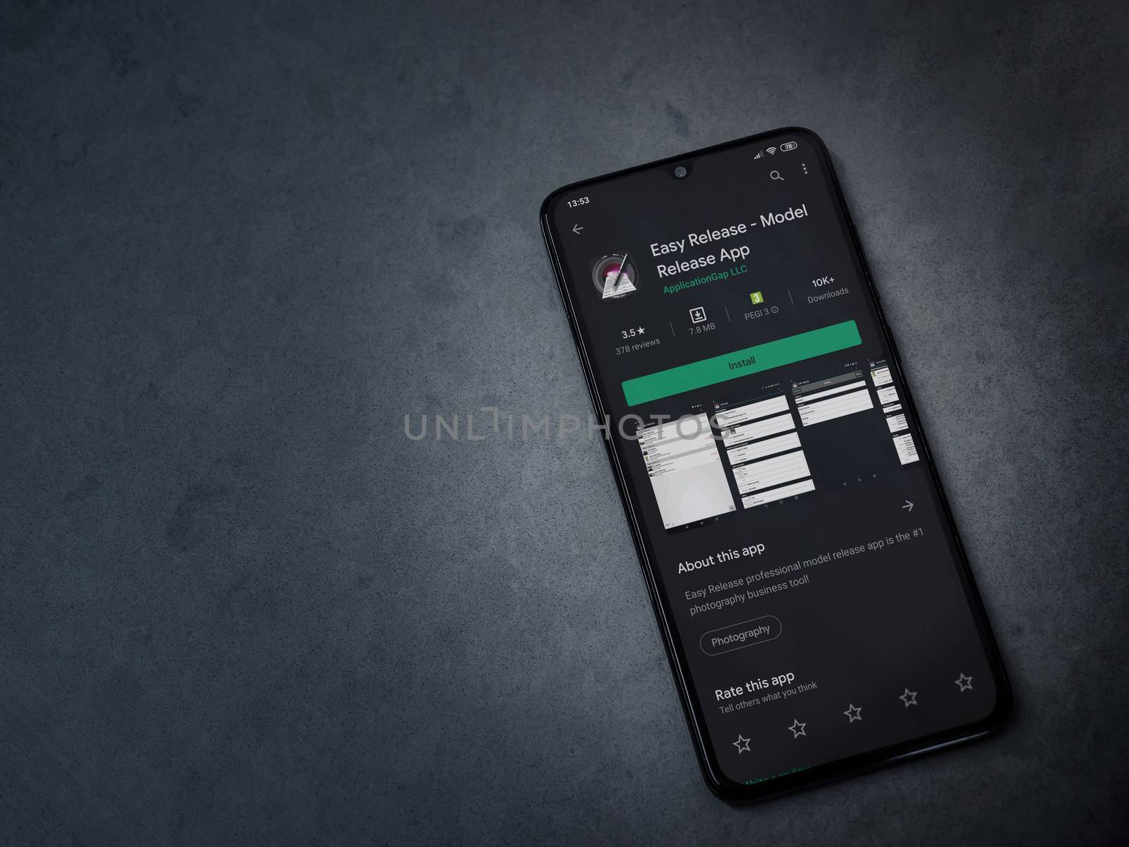 Lod, Israel - July 8, 2020: Easy Release Pro - Model Release app play store page on the display of a black mobile smartphone on a dark marble stone background. Top view flat lay with copy space. 