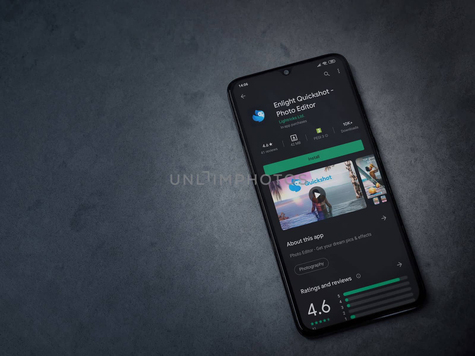 Lod, Israel - July 8, 2020: Enlight Quickshot app play store page on the display of a black mobile smartphone on a dark marble stone background. Top view flat lay with copy space.