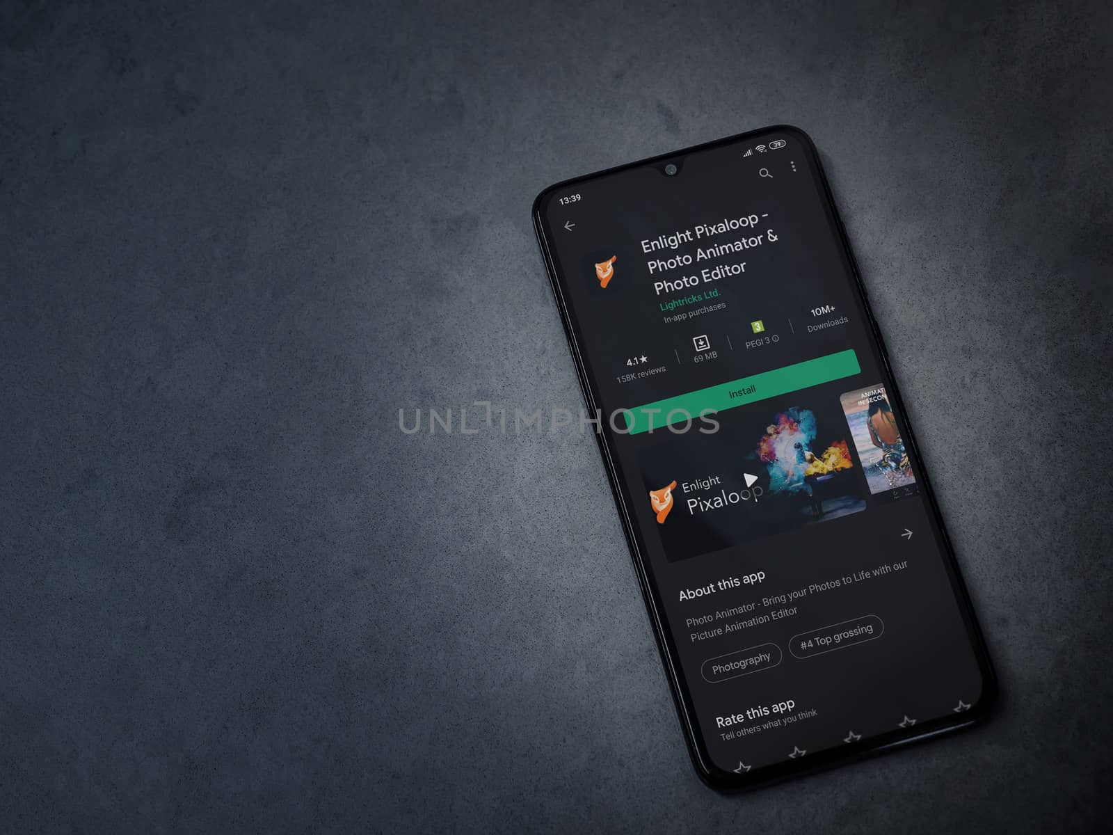 Lod, Israel - July 8, 2020: Enlight Pixaloop app play store page on the display of a black mobile smartphone on a dark marble stone background. Top view flat lay with copy space.