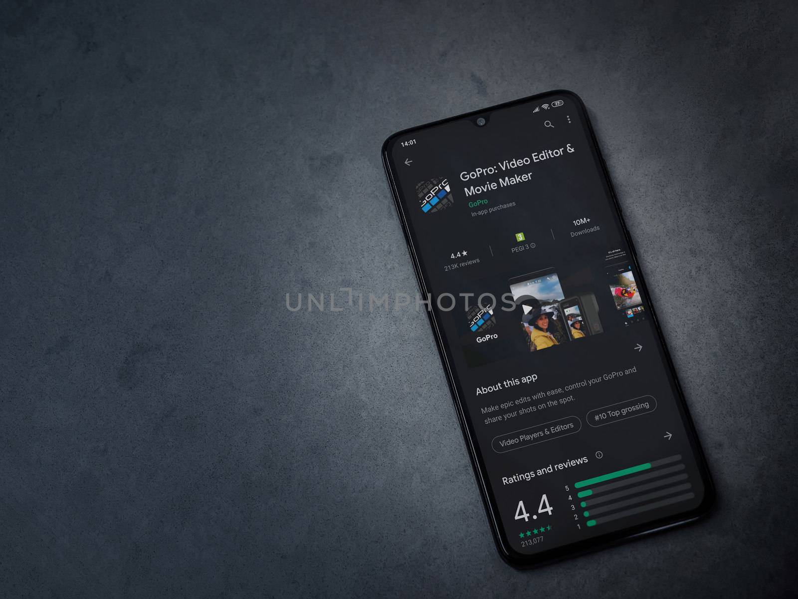 Lod, Israel - July 8, 2020: GoPro - Video Editor and Movie Maker app play store page on the display of a black mobile smartphone on a dark marble stone background. Top view flat lay with copy space.