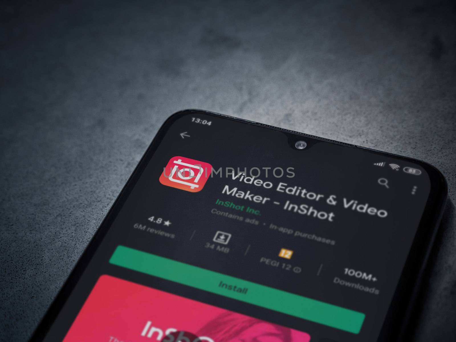 Lod, Israel - July 8, 2020: InShot - Video Editor and Movie Maker app play store page on the display of a black mobile smartphone on a dark marble stone background. Top view flat lay with copy space.