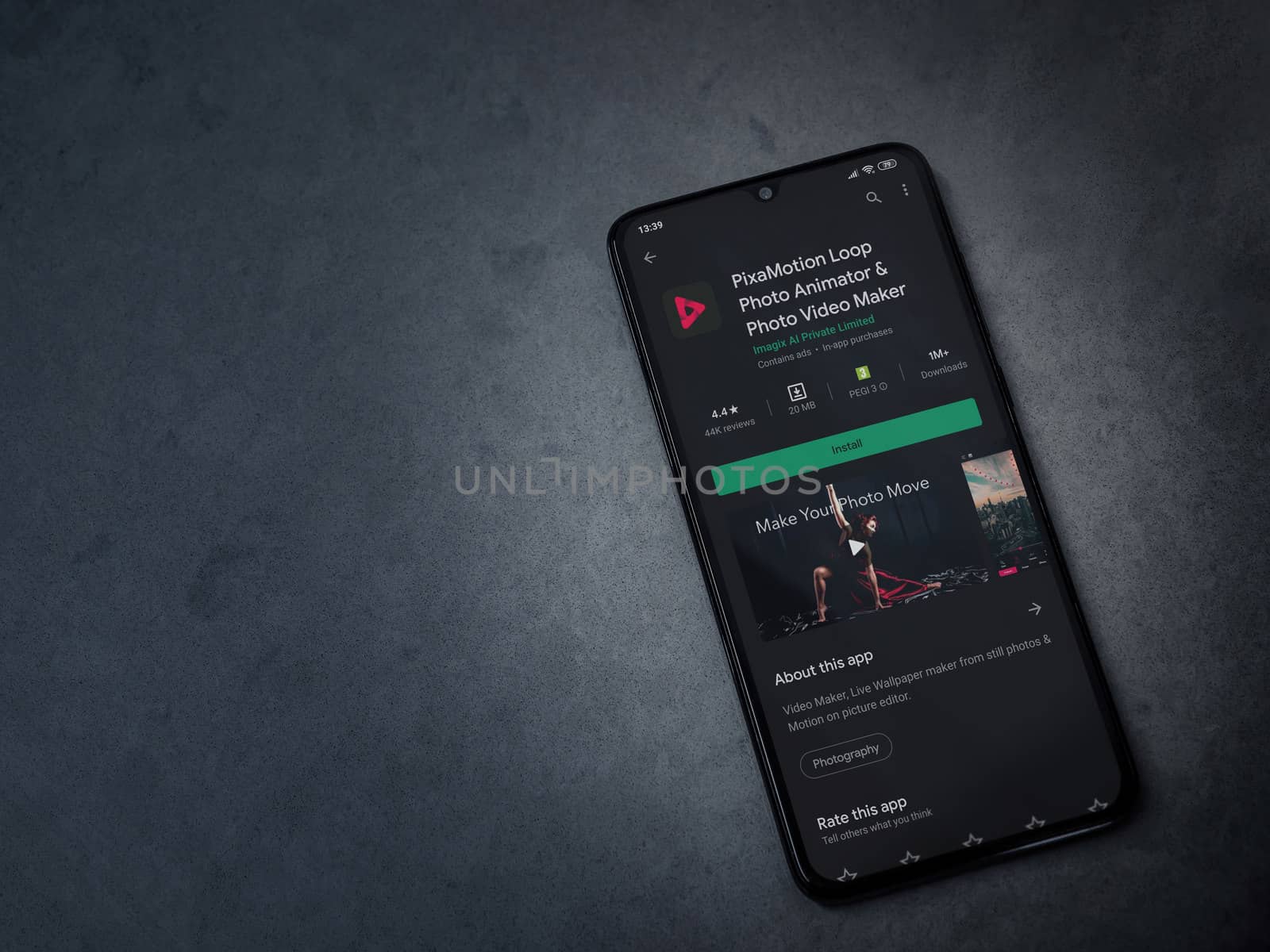 Lod, Israel - July 8, 2020: PixaMotion app play store page on the display of a black mobile smartphone on a dark marble stone background. Top view flat lay with copy space.