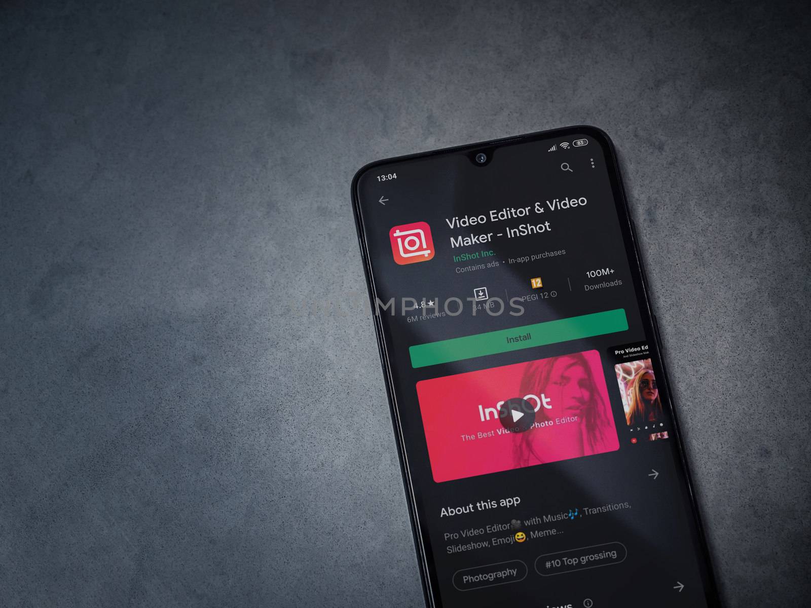 Lod, Israel - July 8, 2020: InShot - Video Editor and Movie Maker app play store page on the display of a black mobile smartphone on a dark marble stone background. Top view flat lay with copy space.