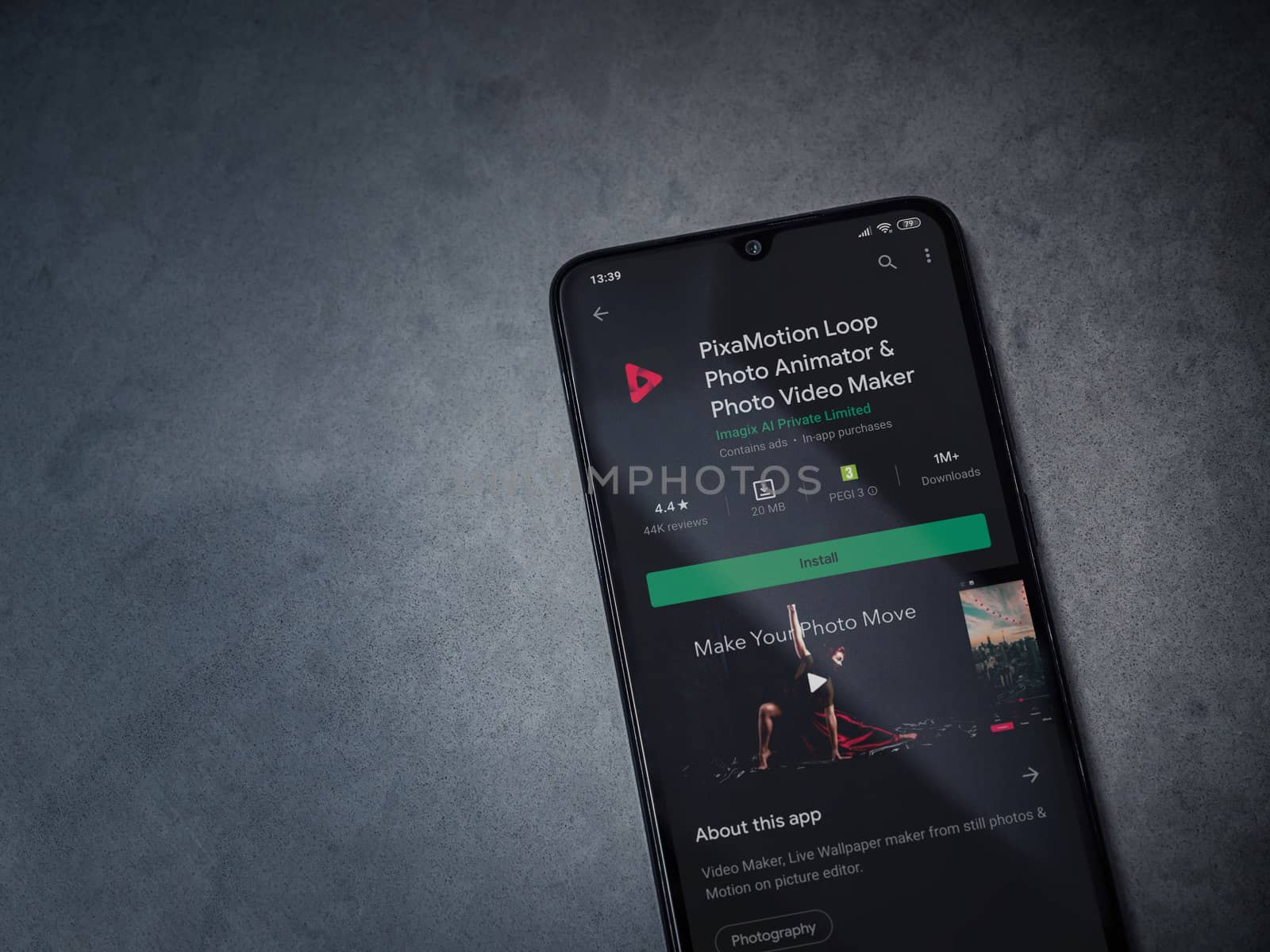 Lod, Israel - July 8, 2020: PixaMotion app play store page on the display of a black mobile smartphone on a dark marble stone background. Top view flat lay with copy space.