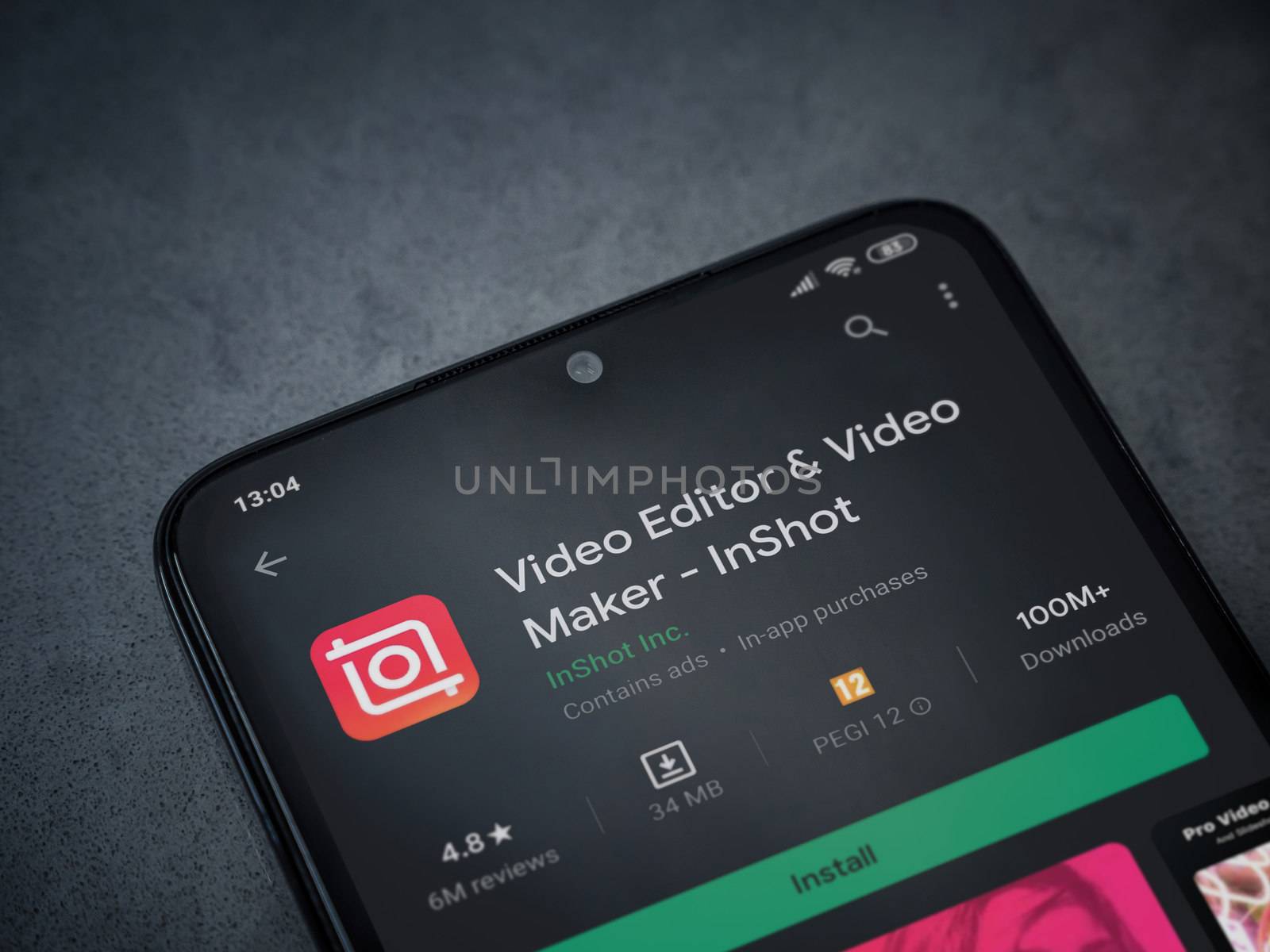 Lod, Israel - July 8, 2020: InShot - Video Editor and Movie Maker app play store page on the display of a black mobile smartphone on a dark marble stone background. Top view flat lay with copy space.
