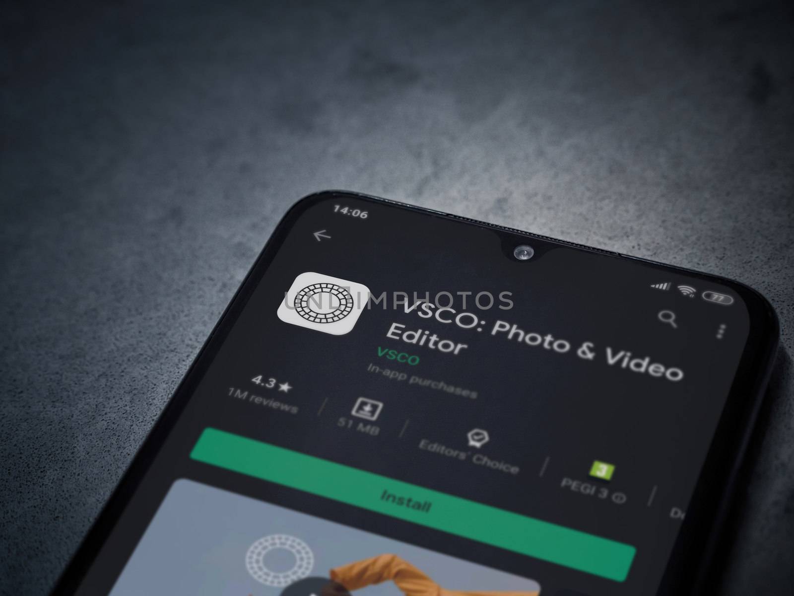 Lod, Israel - July 8, 2020: VSCO - Photo and Video Editor app play store page on the display of a black mobile smartphone on a dark marble stone background. Top view flat lay with copy space. 
