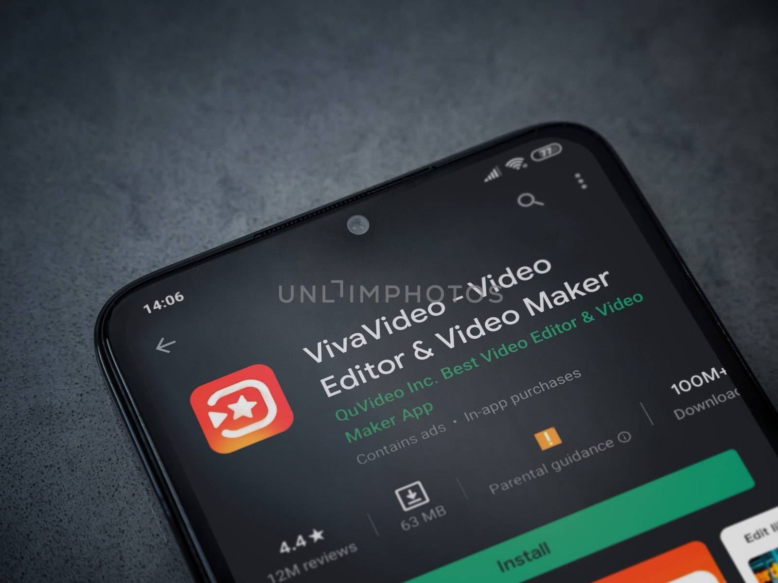 Lod, Israel - July 8, 2020: VivaVideo - Video Editor and Movie Maker app play store page on the display of a black mobile smartphone on a dark marble stone background. Top view flat lay with copy space.
