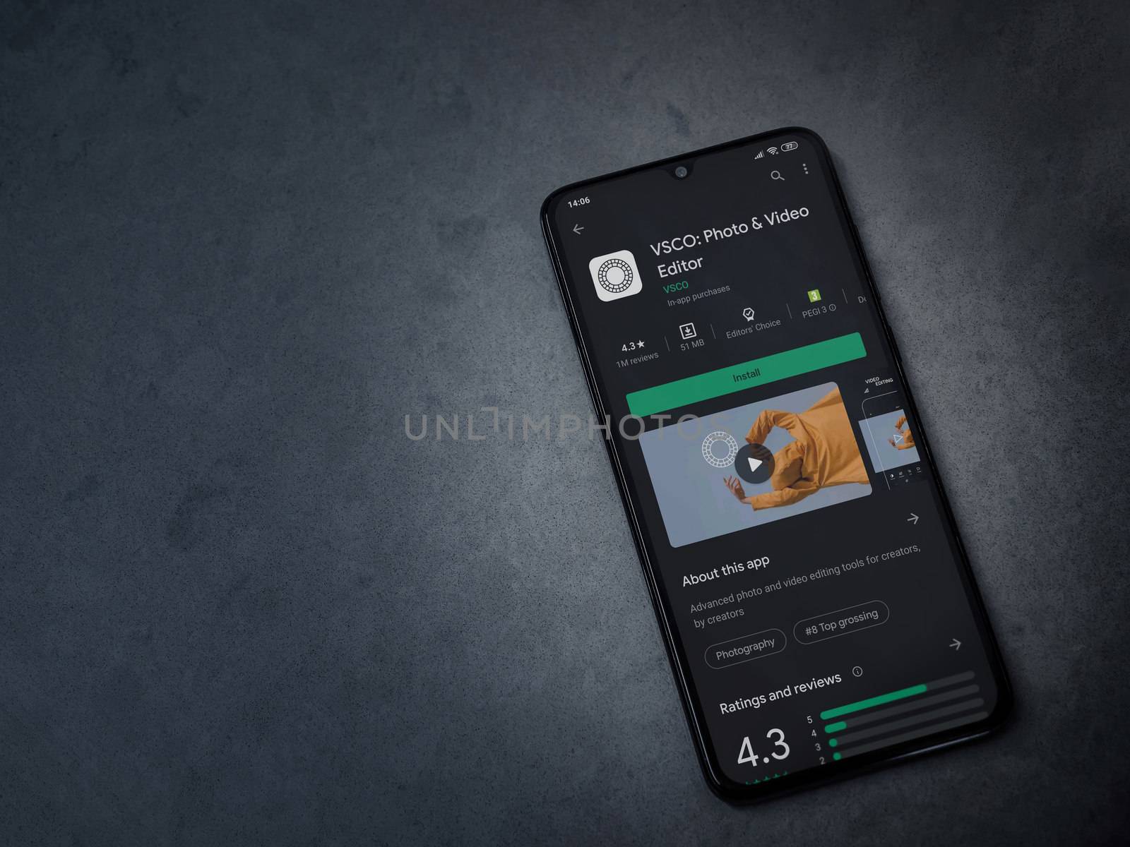Lod, Israel - July 8, 2020: VSCO - Photo and Video Editor app play store page on the display of a black mobile smartphone on a dark marble stone background. Top view flat lay with copy space. 