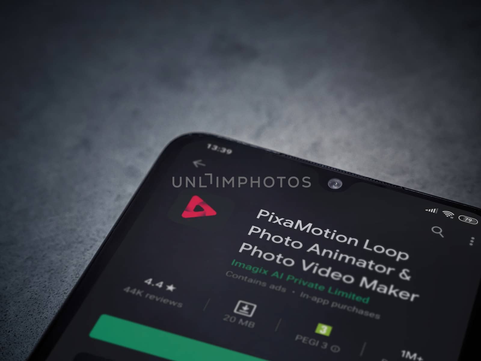 Lod, Israel - July 8, 2020: PixaMotion app play store page on the display of a black mobile smartphone on a dark marble stone background. Top view flat lay with copy space.