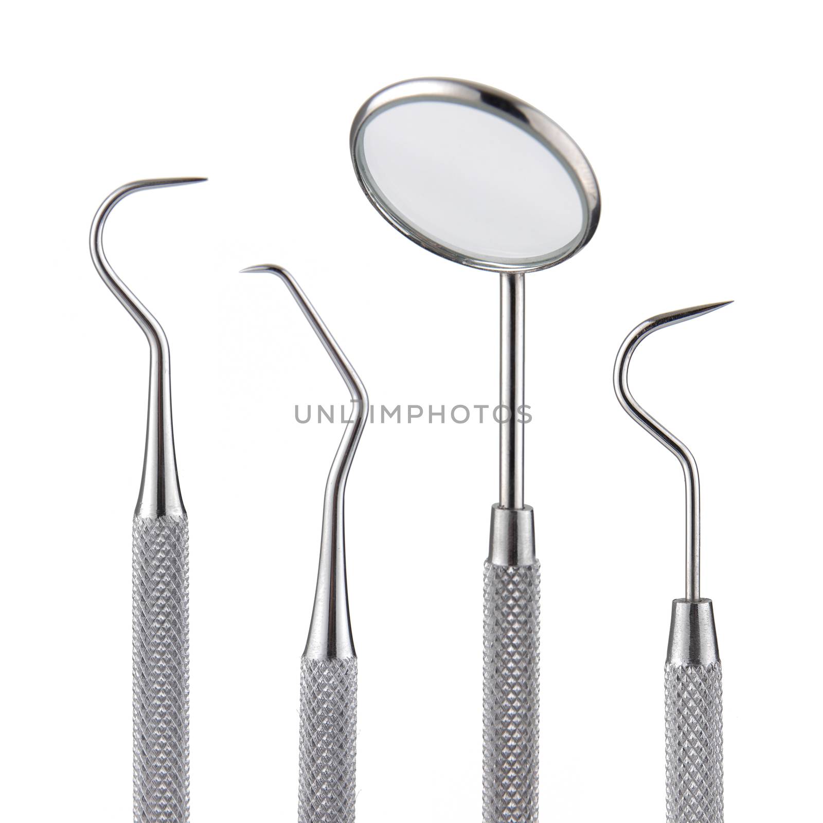 A set of dental tools. Mirror scaler and sickle probe dental explorer on white