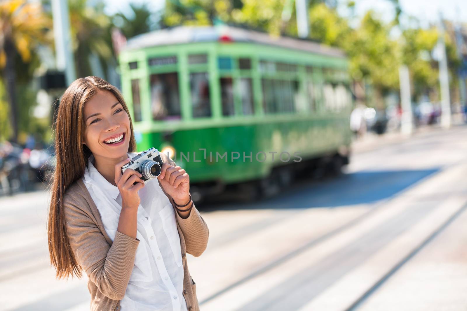 Asian woman tourist -city street lifestyle, famous tramway cable car system in San Francisco city, California during summer vacation. Travel fun taking pictures with vintage camera. by Maridav