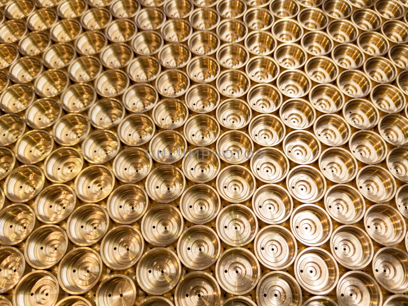 an abstract perspective industrial close-up background of shiny brass metal threaded hexagonal fitting parts.