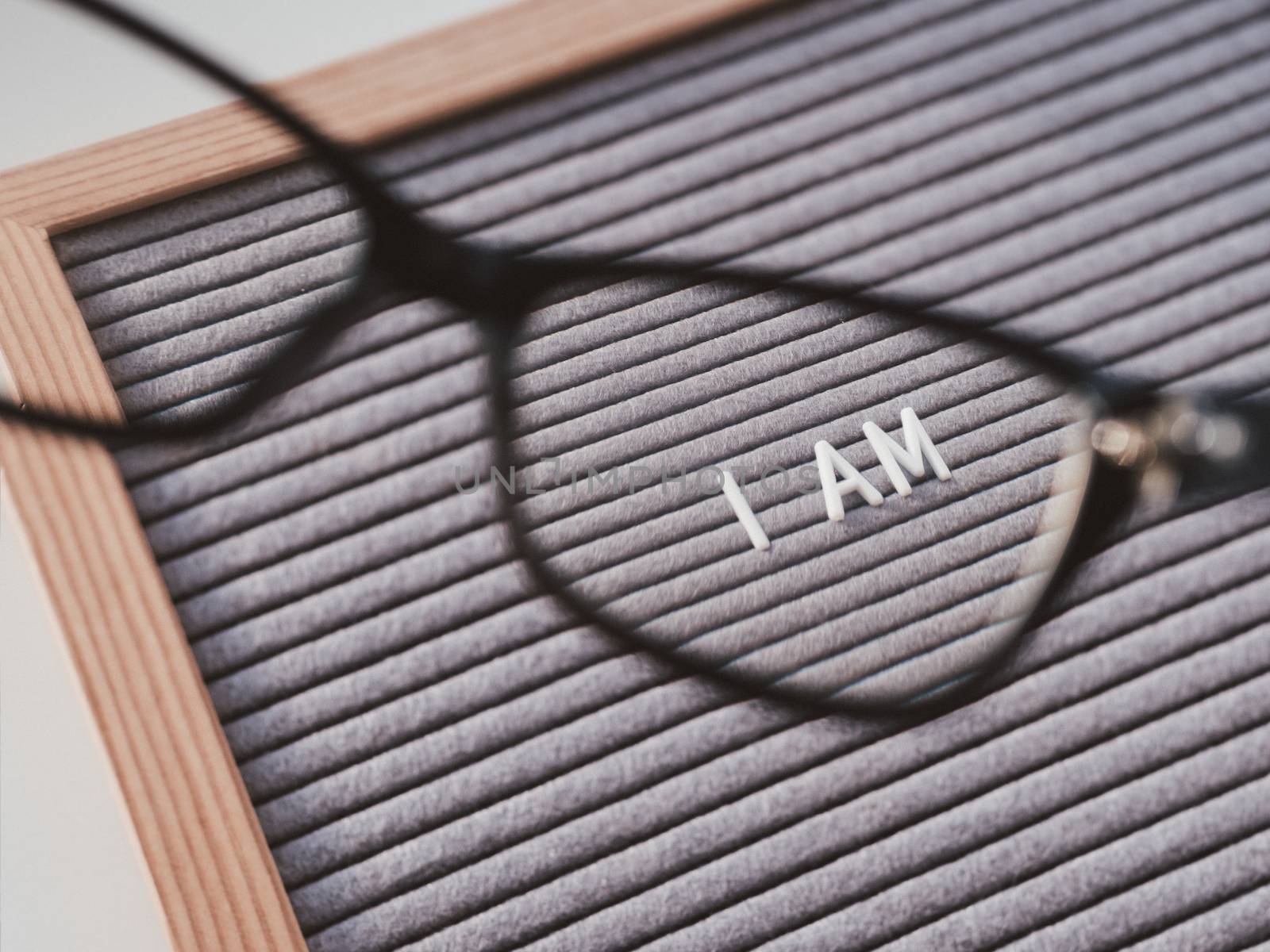 Top view on letterboard with words I AM through eyeglasses. Flat lay concept of psychological self-regulation or gender gender identity. Social psycological issue. Closer look on psychological problems.